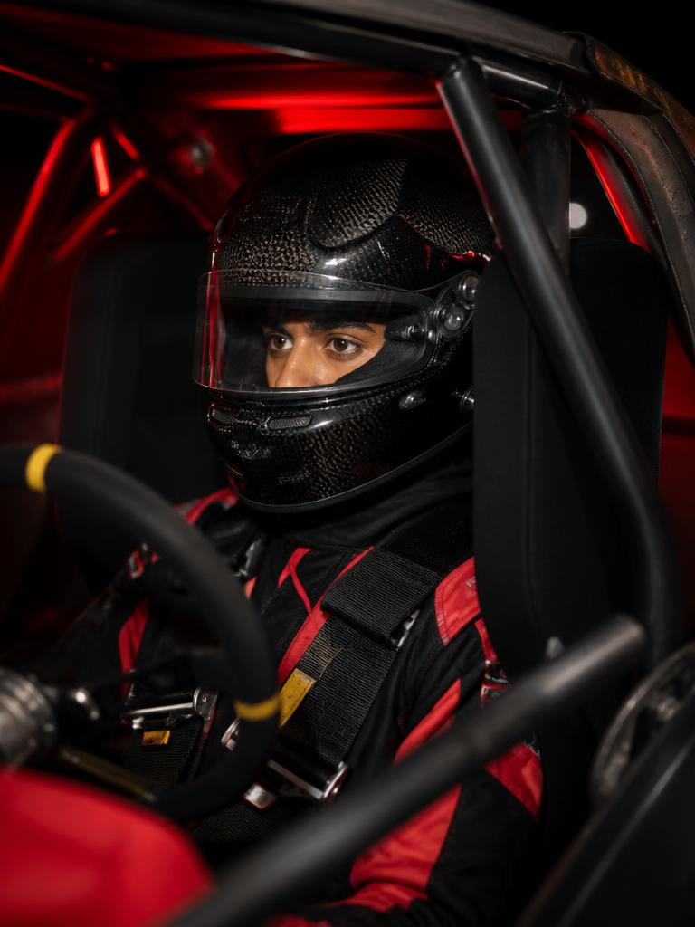 Rookie driver helmeted inside a race car roll cage